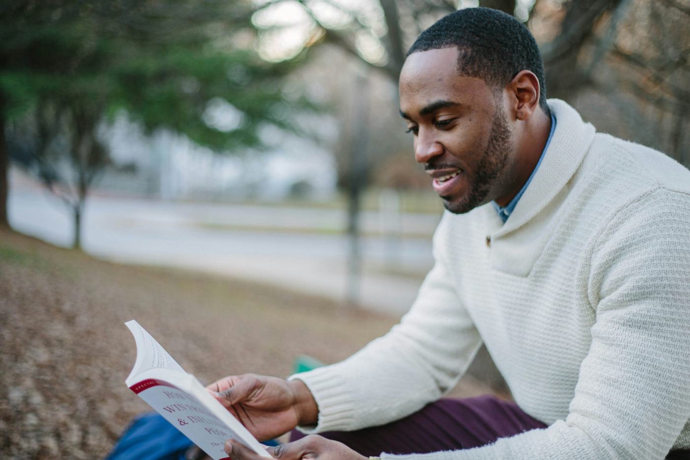 An adult learner reading outdoors