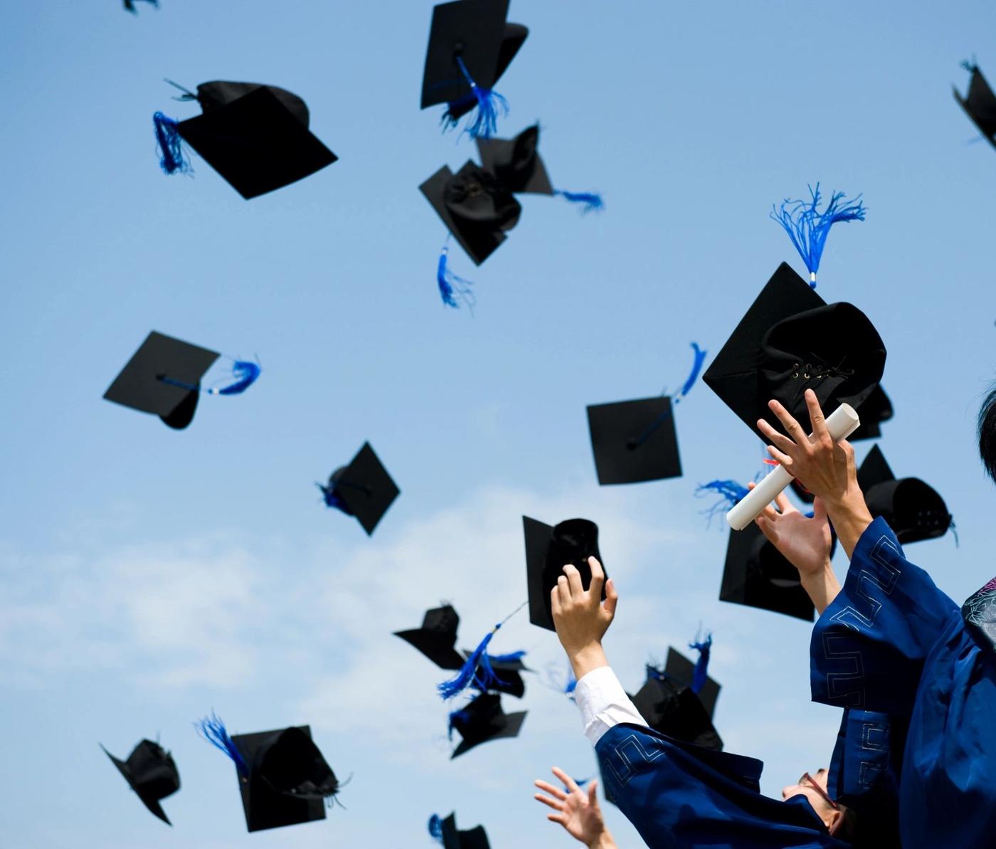 Graduates tossing their caps into a blue sky